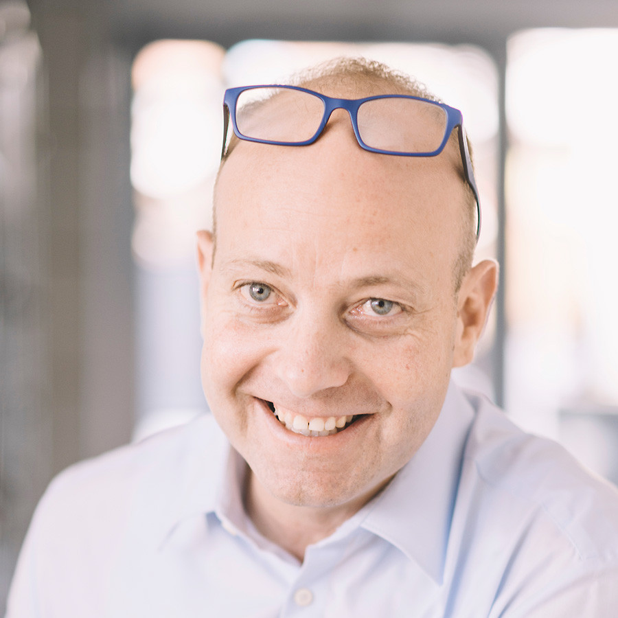 Tom Huber lächelt freundlich und gewinnend in die Kamera.